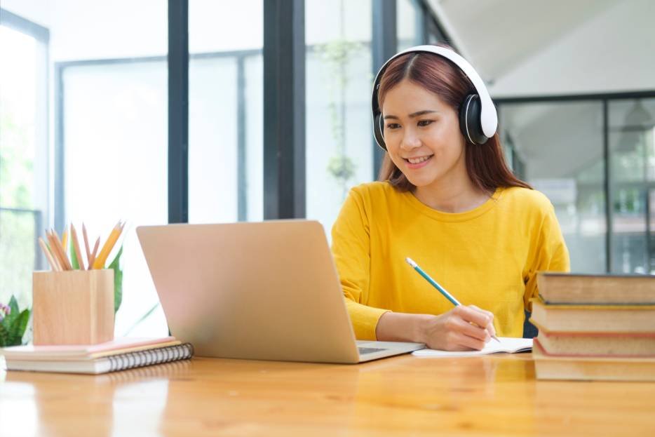 Alumna estudia con ayuda de una guía un simulador de examen 