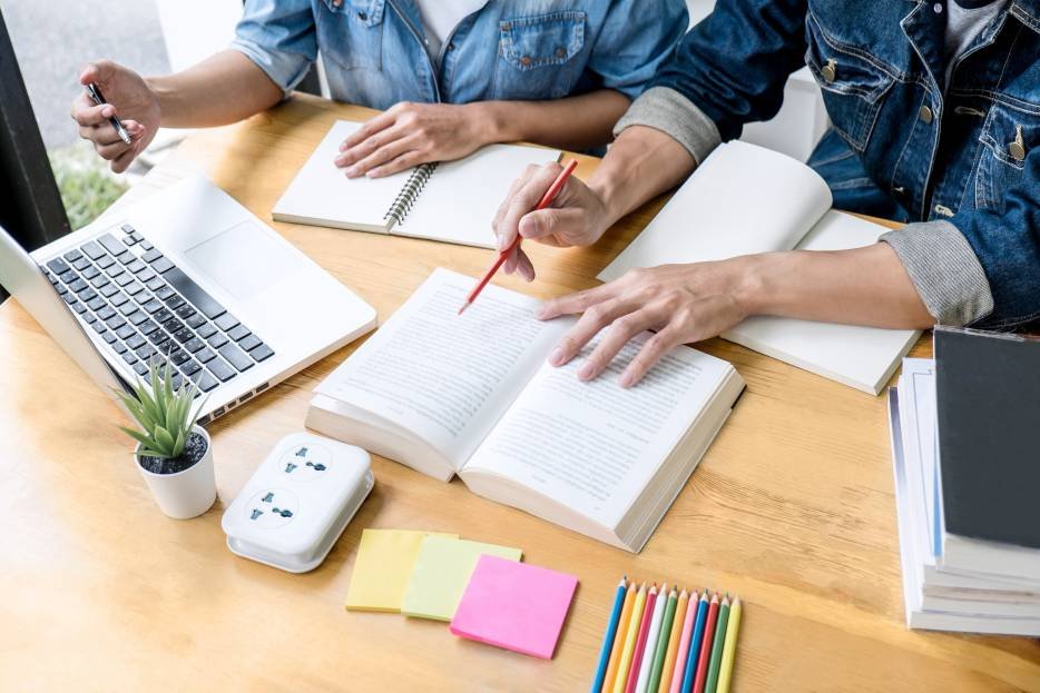 estudiantes repasan su material de estudio con una guía